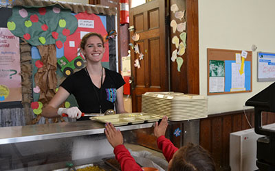 Volunteer Nicole Bialick serves lunch to a student.