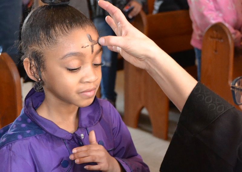 A student receives ashes on Ash Wednesday.