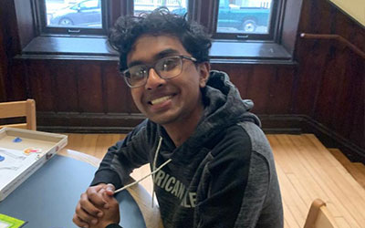Volunteer Pratiif Kaushik sits at a table.